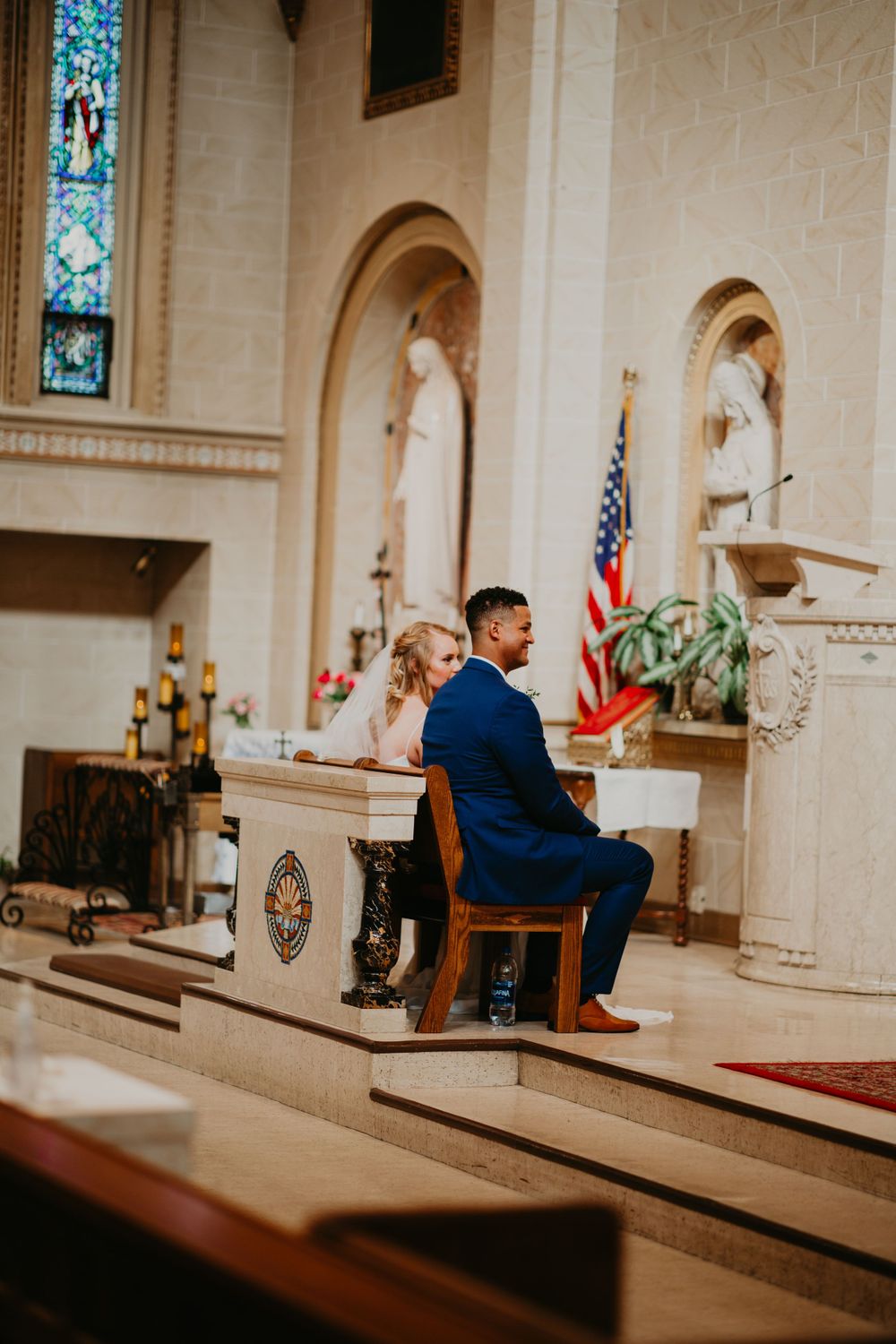 Bride and groom seated together at the church altar during their wedding ceremony.