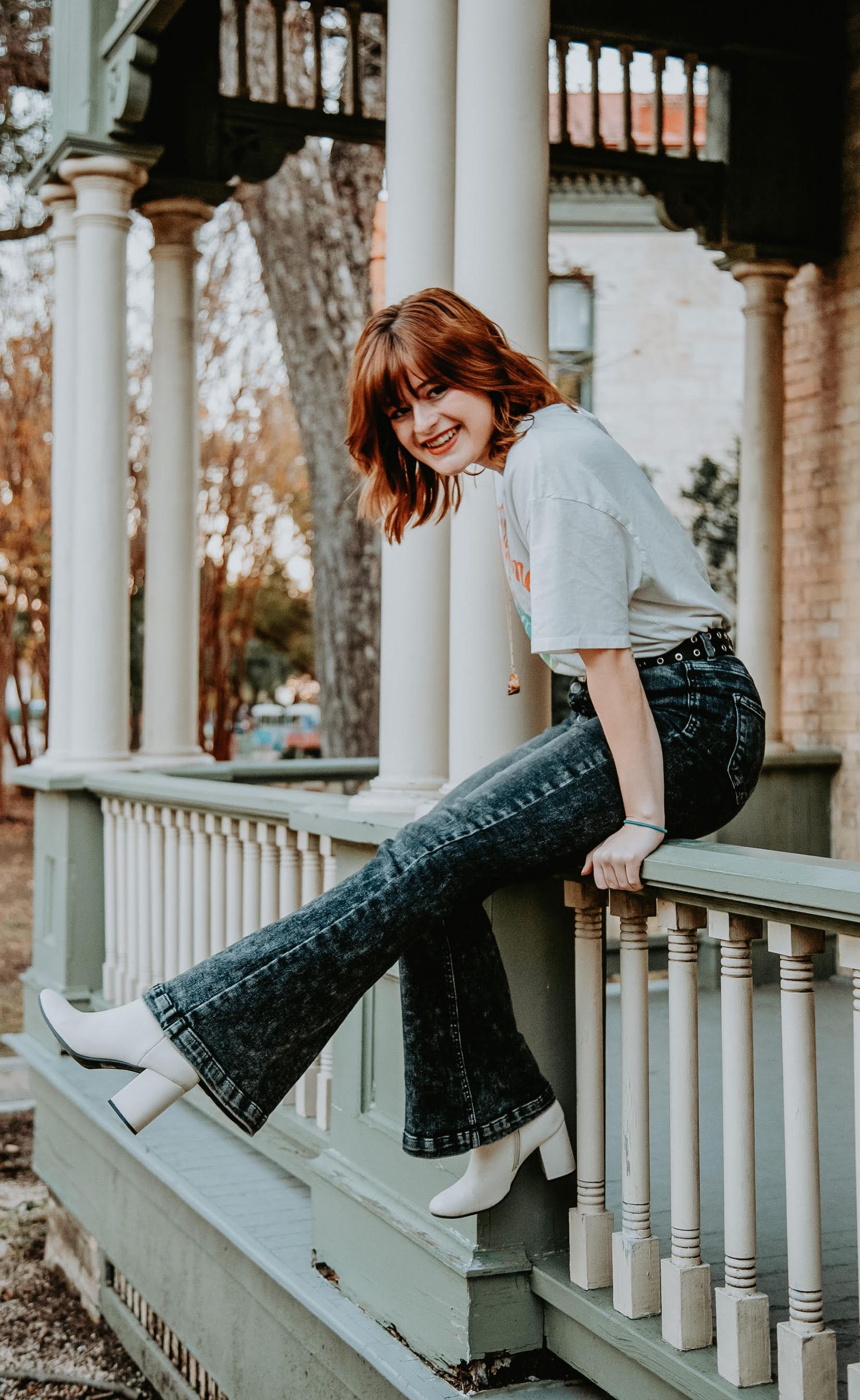 Girl hanging off house railing.