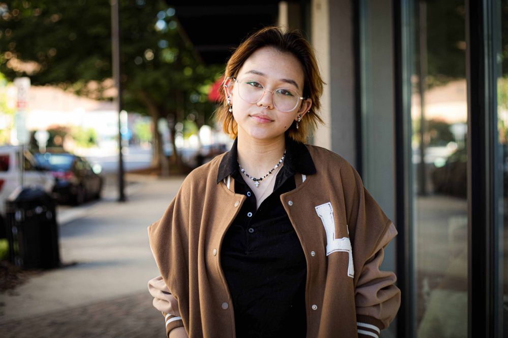senior in letterman jacket in downtown high point by victoria leigh photography