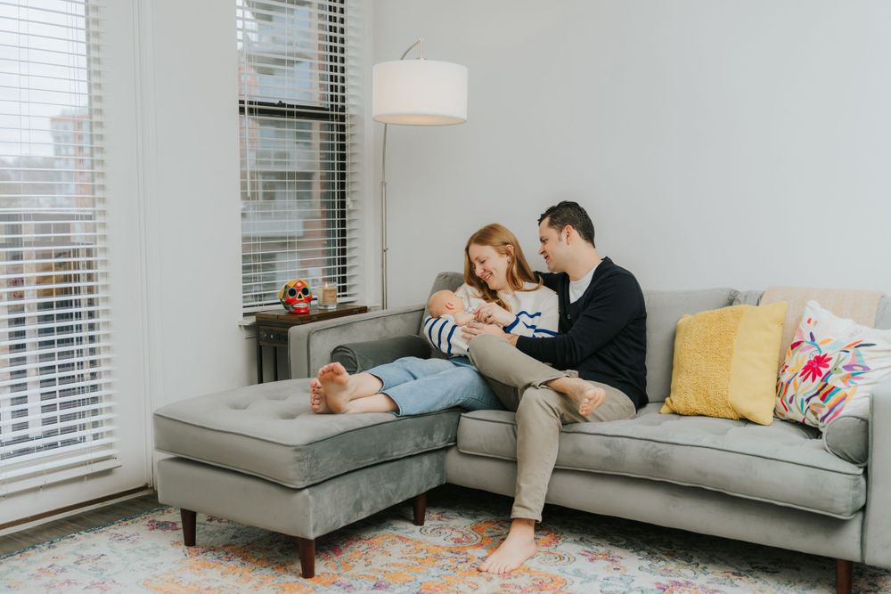 Couple relaxing together on grey sectional sofa in modern living room.