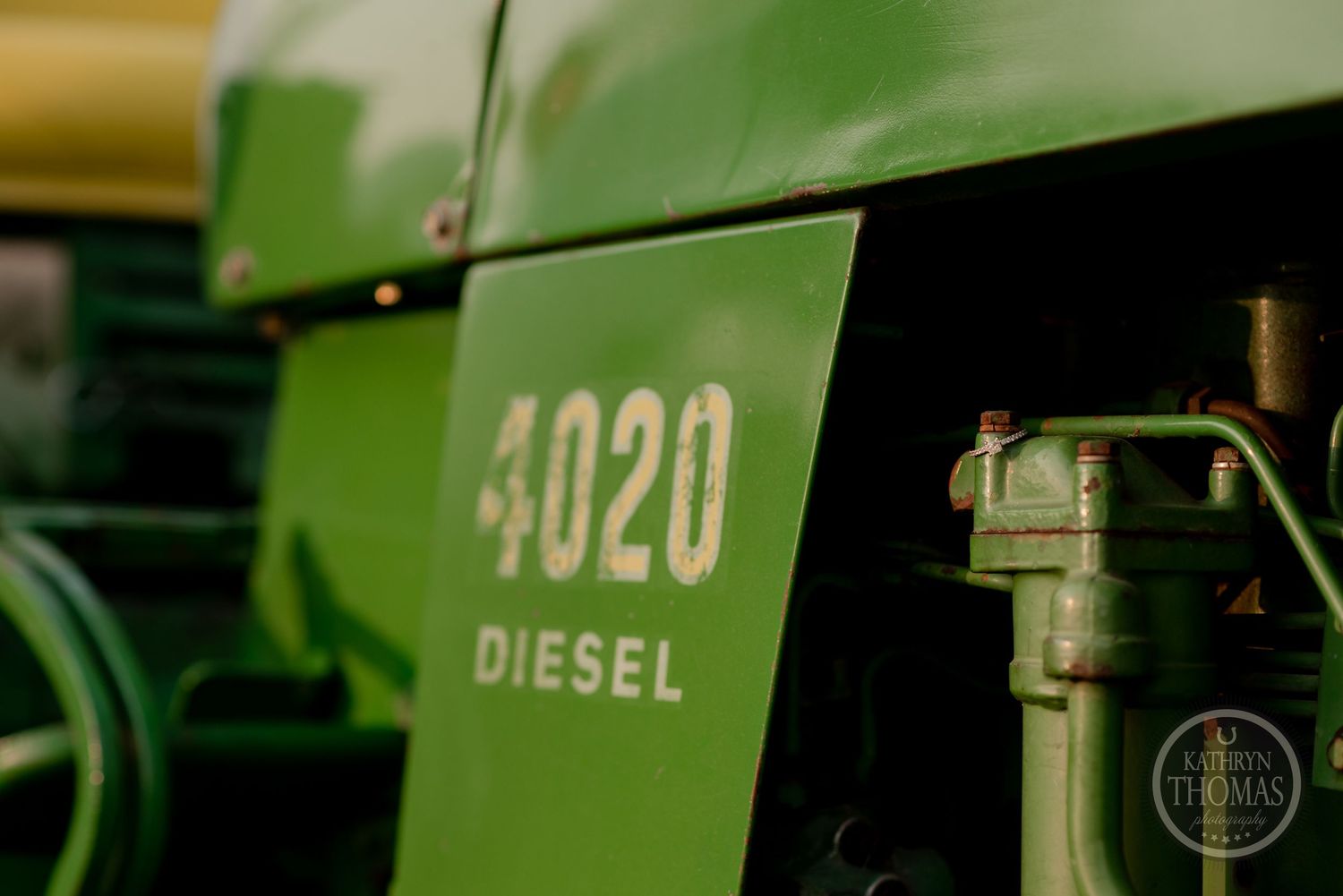 Close up detail of a green John Deere 4020 diesel tractor showing model number.