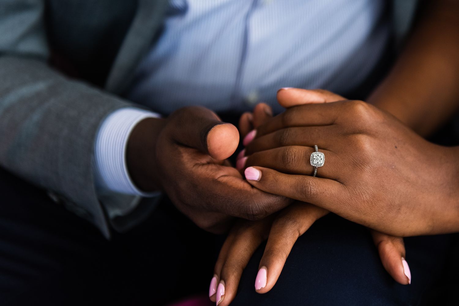 Couple holds hands with beautiful engagement ring