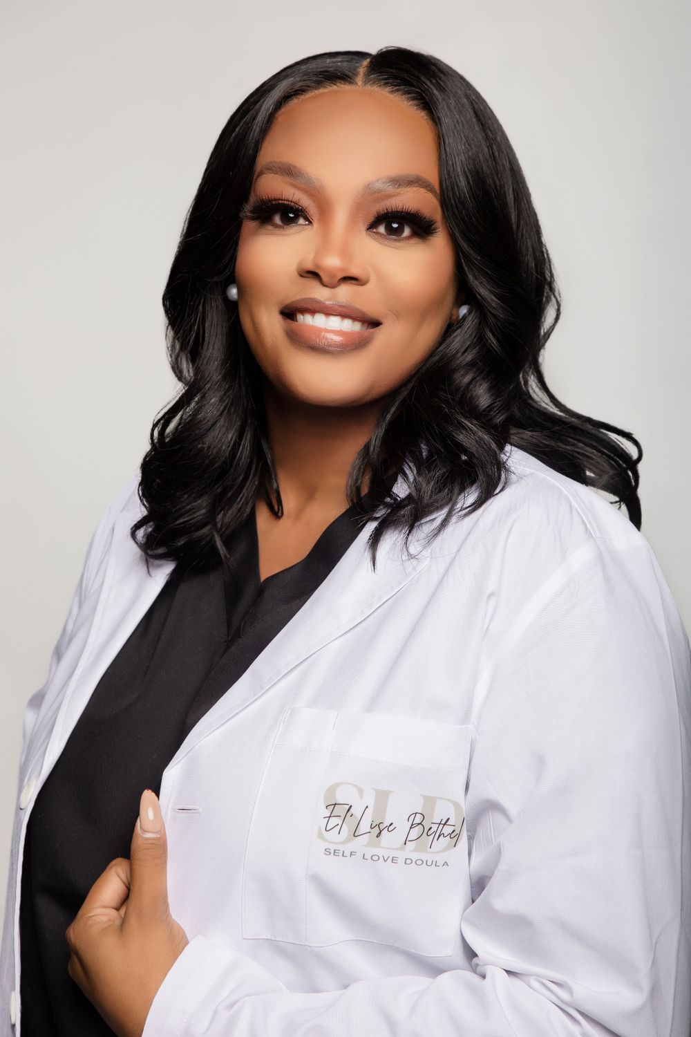 Professional headshots of a person in white medical coat and black top against light background.