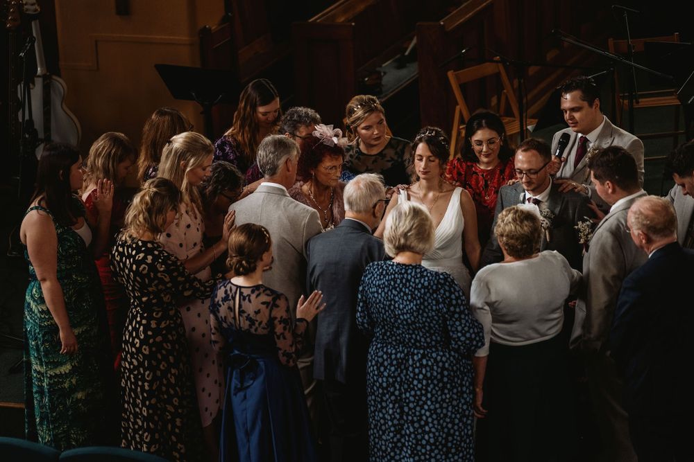 Large group of wedding guests gathered together for a special moment during the reception.