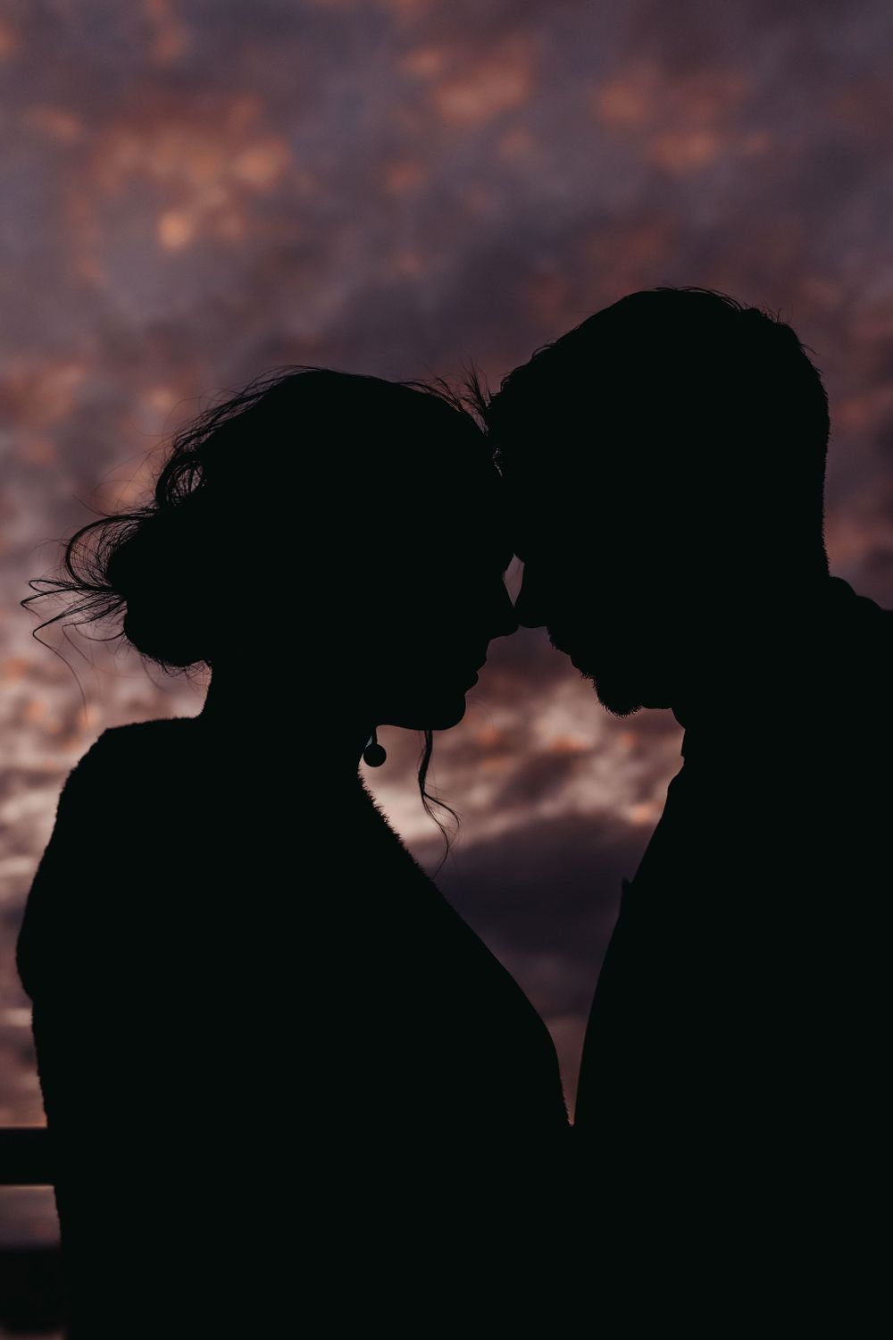 Silhouette of a romantic couple against a dramatic sunset sky.