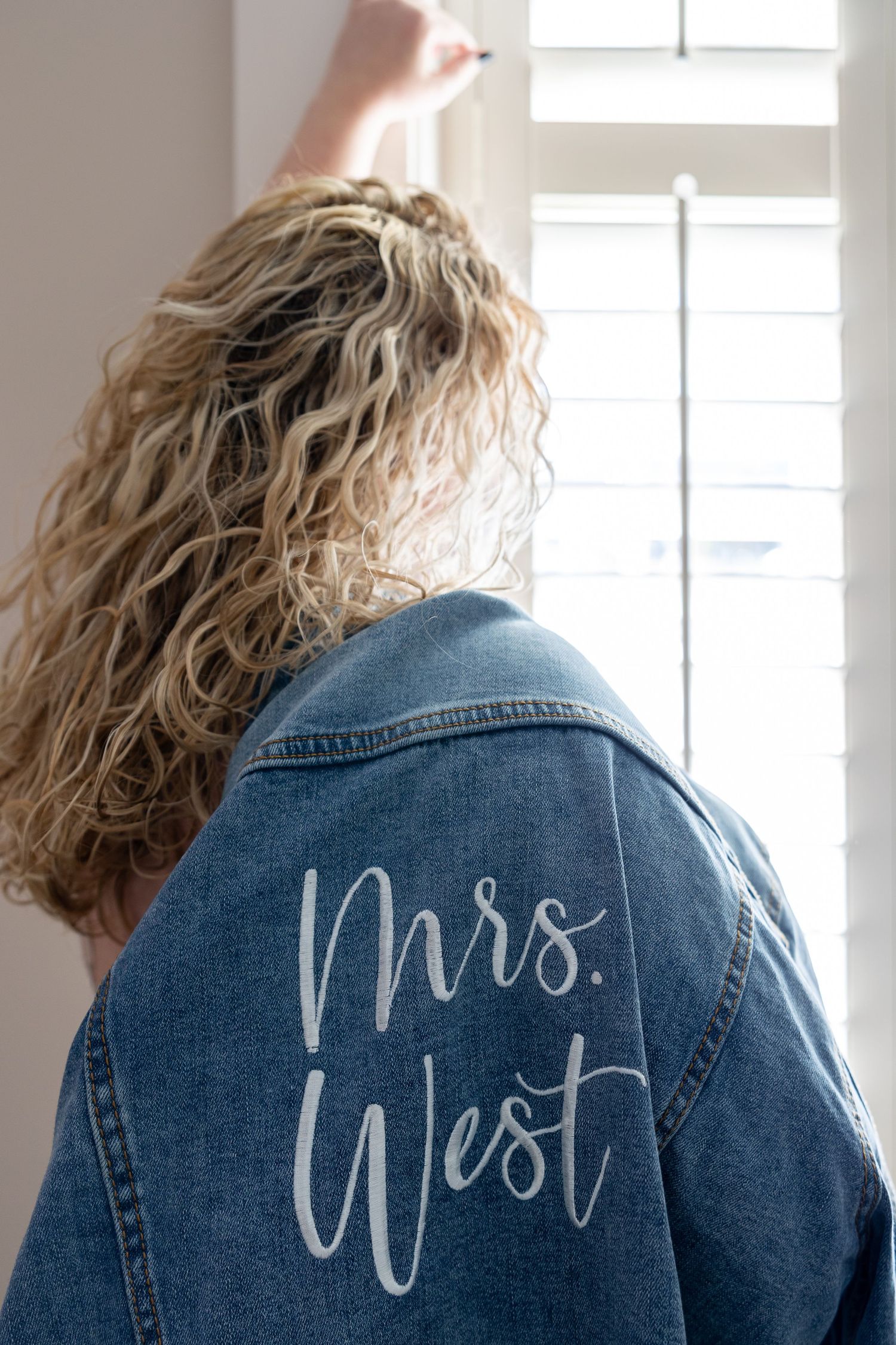 Denim jacket with 'Mrs.' text written in white script lettering on the back.