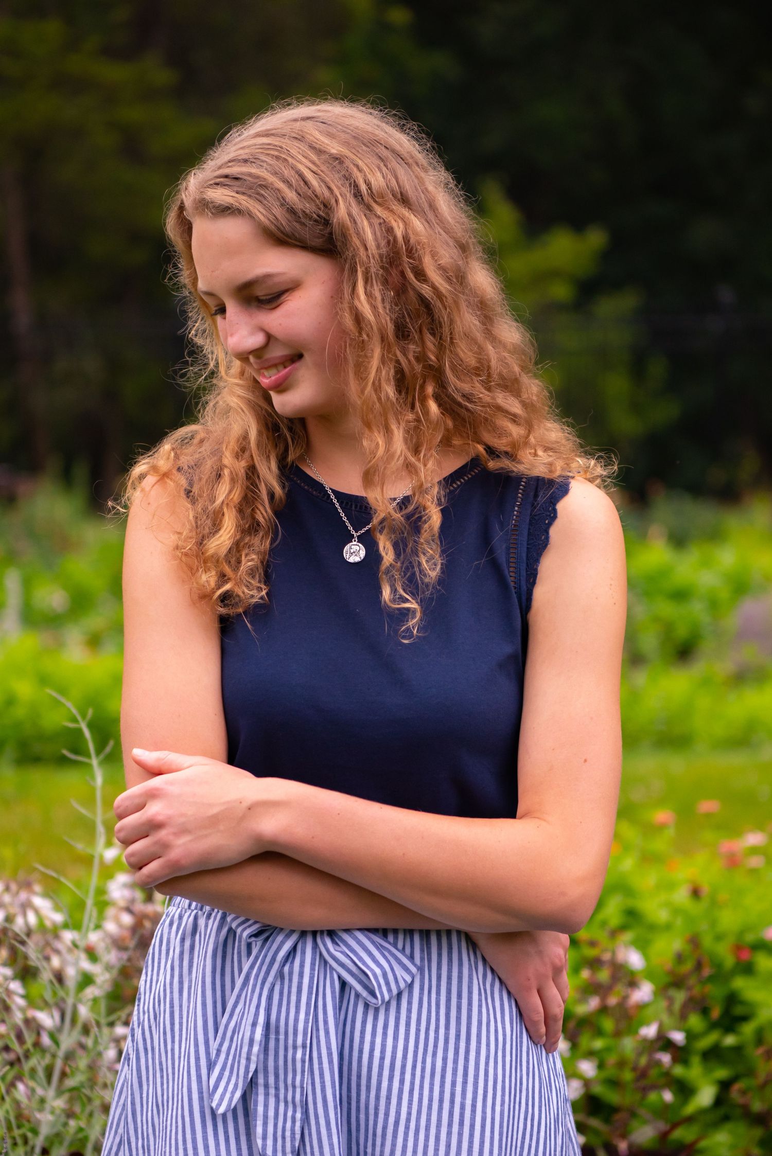 portrait of high school girl in flower field looking off in the distance