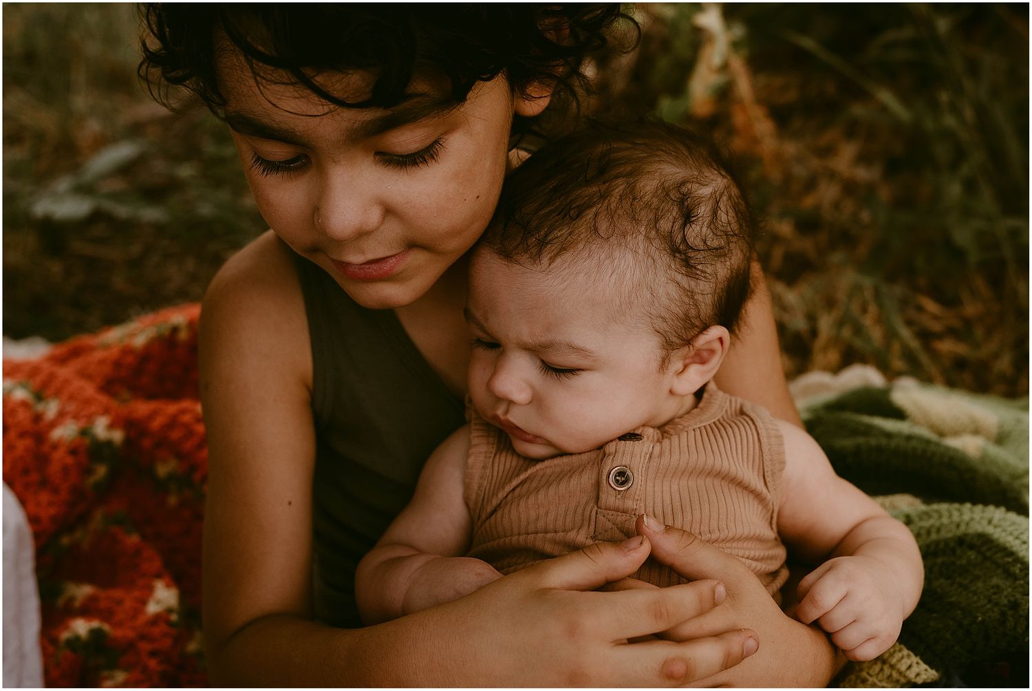 A tender moment captured between a caregiver and infant in warm, natural lighting.