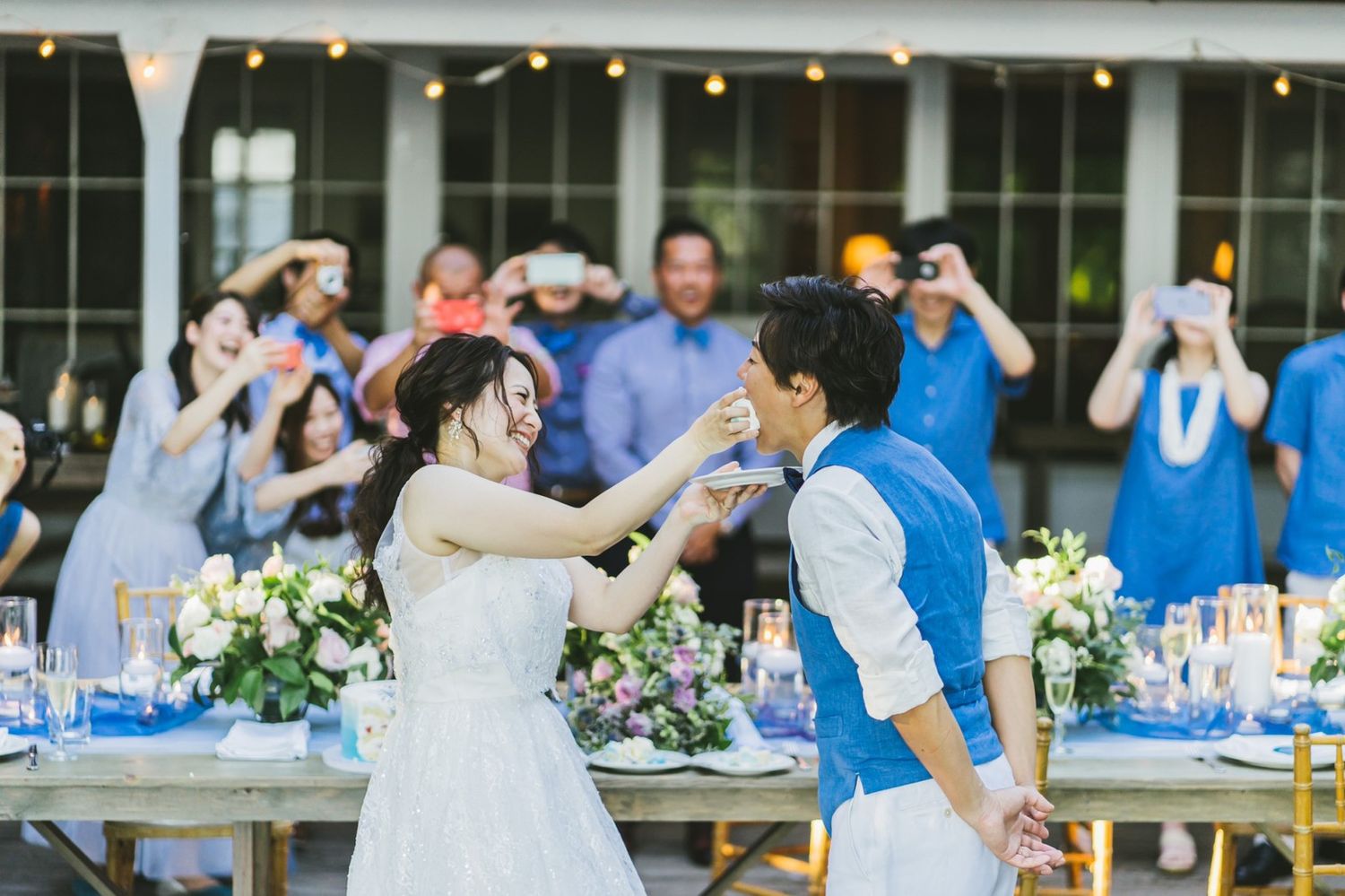 Bride and groom share a dance at an outdoor wedding reception with guests celebrating.