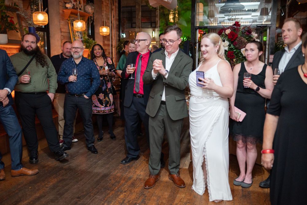 Wedding celebration in a cozy bar venue with exposed brick walls and warm lighting.