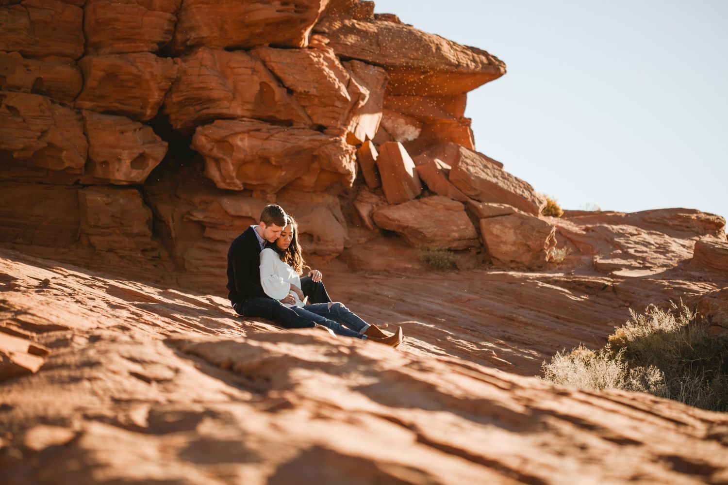 Couple on red rocks. Engagement photography.