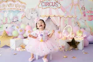 Magical circus-themed birthday party setup with pink and gold decorations, stars, and delicate lighting.