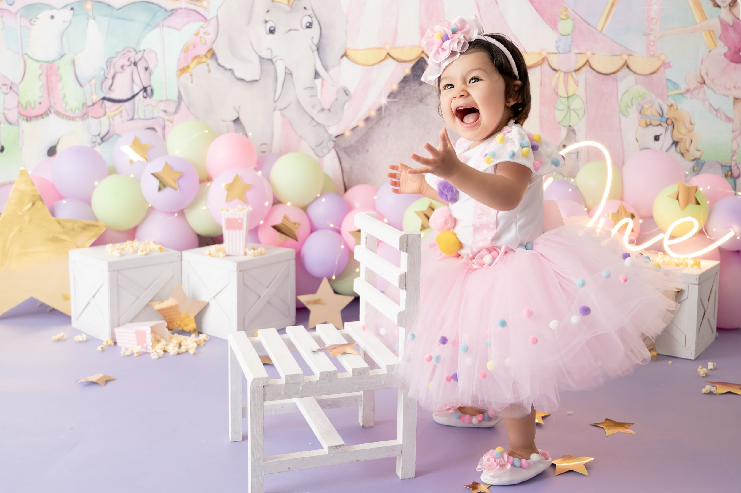 Dreamy pastel unicorn-themed birthday party setup with balloons, tulle, and whimsical decorations in pink and purple tones.