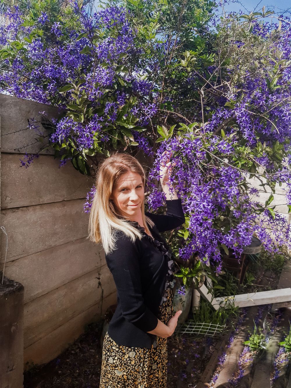 Blooming purple wisteria creates natural backdrop for outdoor portrait.