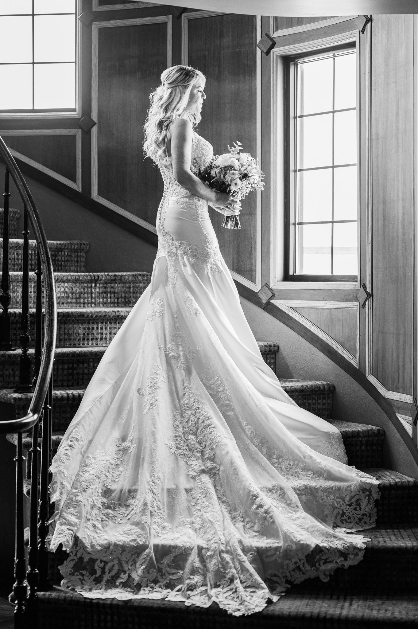 Bride exudes elegance on Land's End staircase, gazing outward.