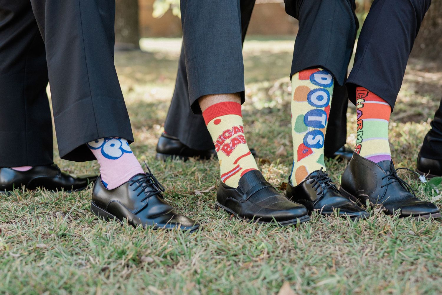 Fun detail shot of groomsmen showing off colorful patterned socks with formal shoes.