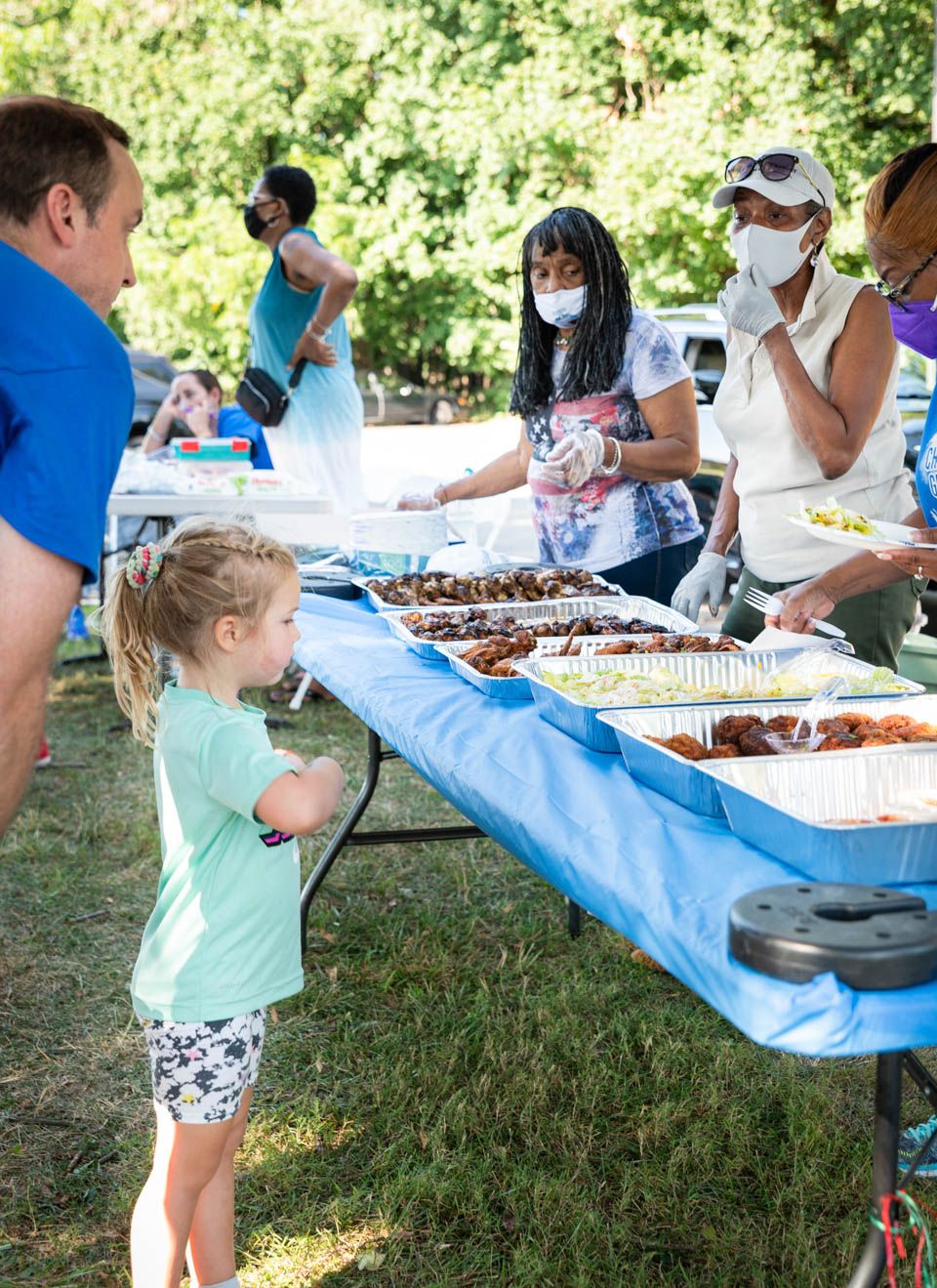 Pixs By Tina captured a family dinner event of people gathered around a buffet table at an outdoor summer event
