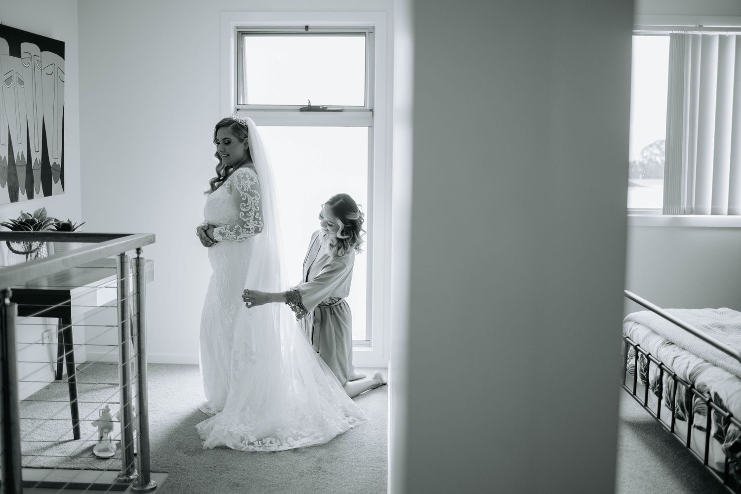 A black and white photo of wedding preparations in a sunlit room.