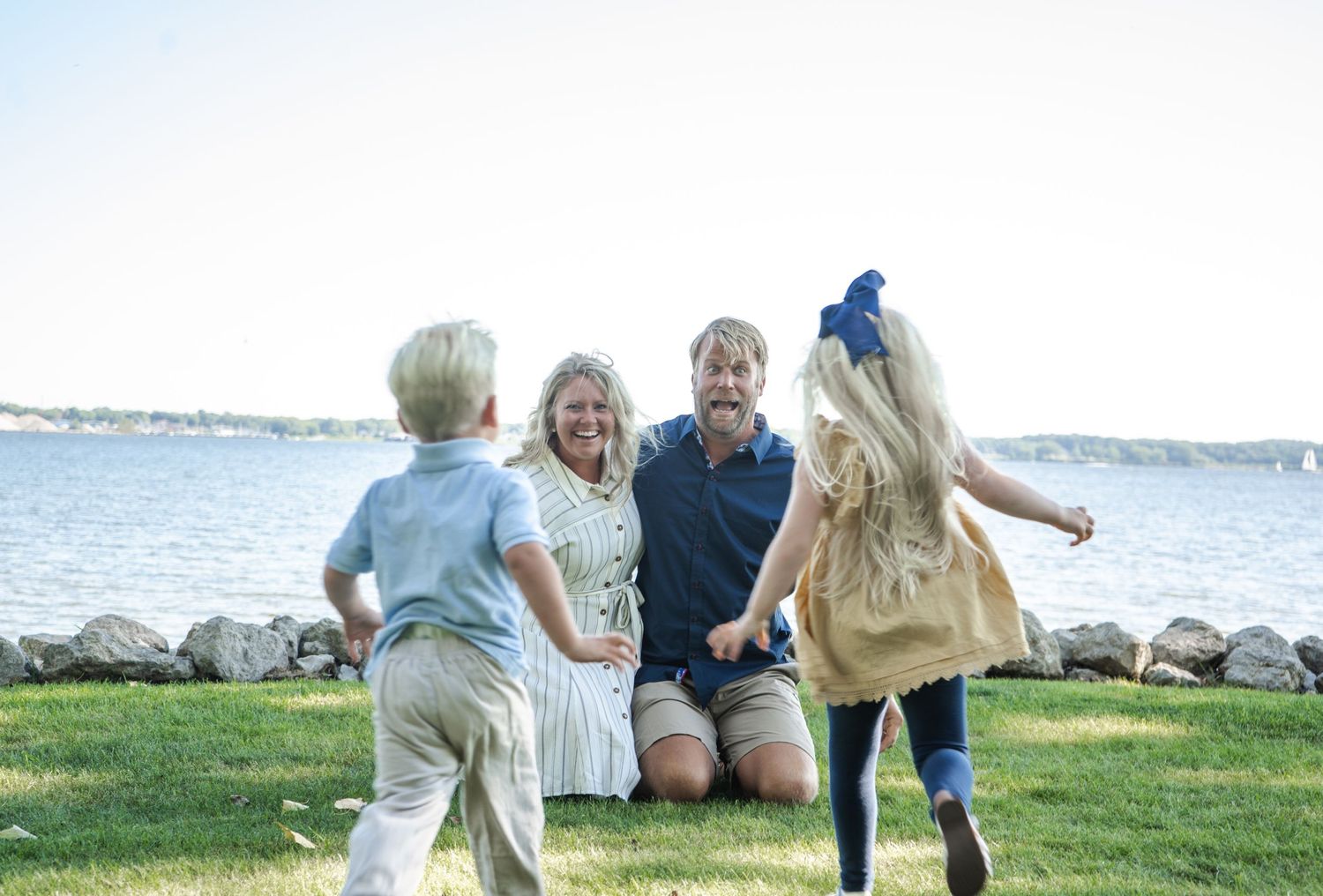 Two young kids running at their parents.