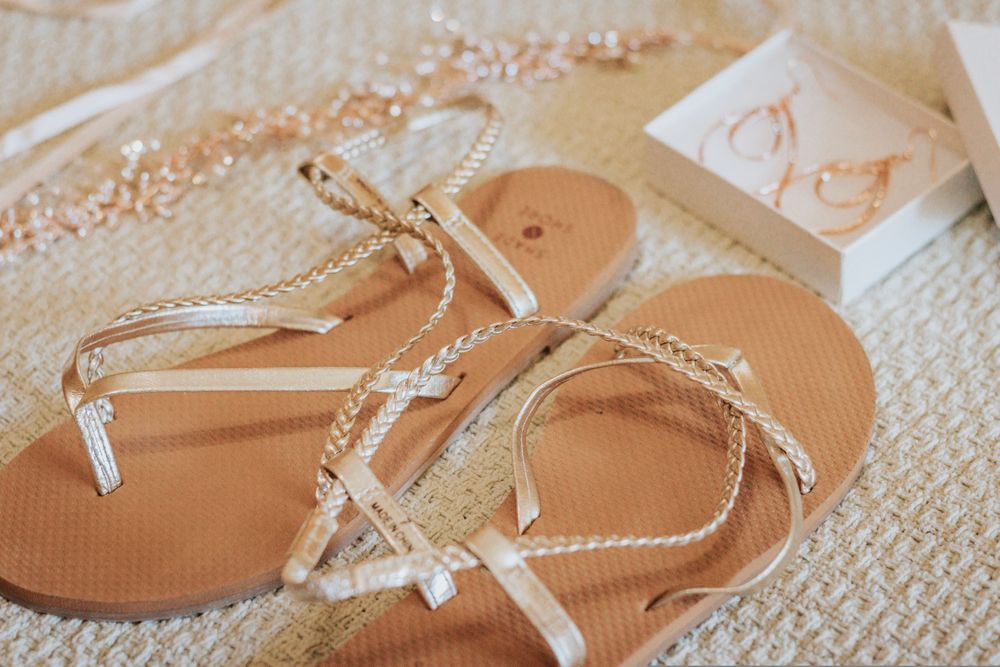 Close-up detail shots of light colored sandals with braided straps on a white surface.