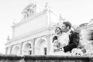Black and white portrait of newlyweds against classical architectural backdrop.