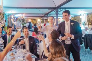 Wedding reception guests celebrate with drinks under blue ambient lighting.