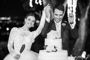 Black and white photo series of a couple's joyful cake cutting moment at their wedding reception.