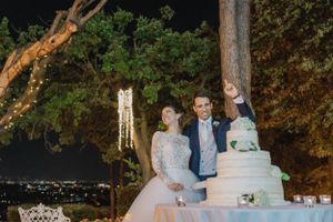 Wedding reception setup outdoors with romantic string lights and trees creating a magical atmosphere.