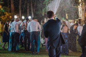 Wedding guests enjoying outdoor celebration with sparklers creating a magical atmosphere.