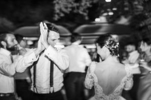 Black and white photos of wedding guests dancing and celebrating at reception.
