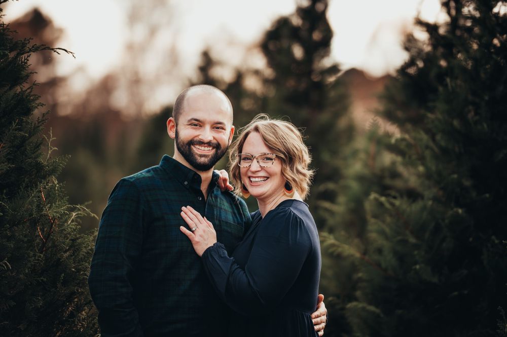 husband and wife hold eachother smiling at Wheeler's Christmas Tree Farm in Tunnell Hill, GA