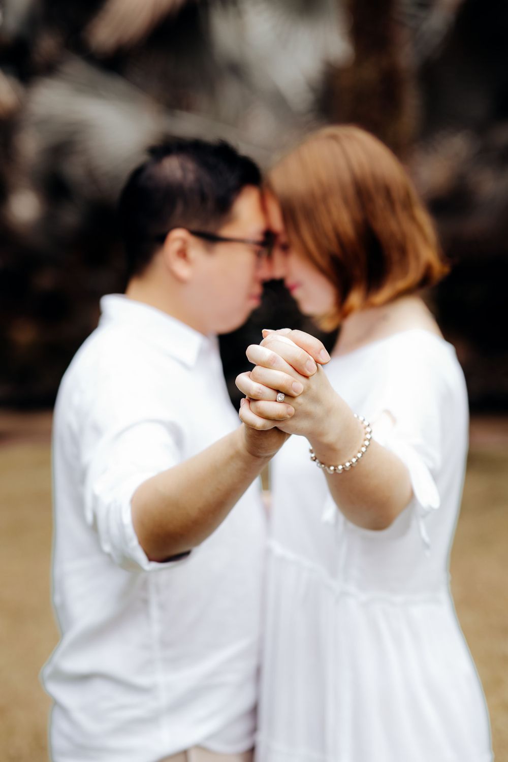 Intimate couple pose while ring is in focus
