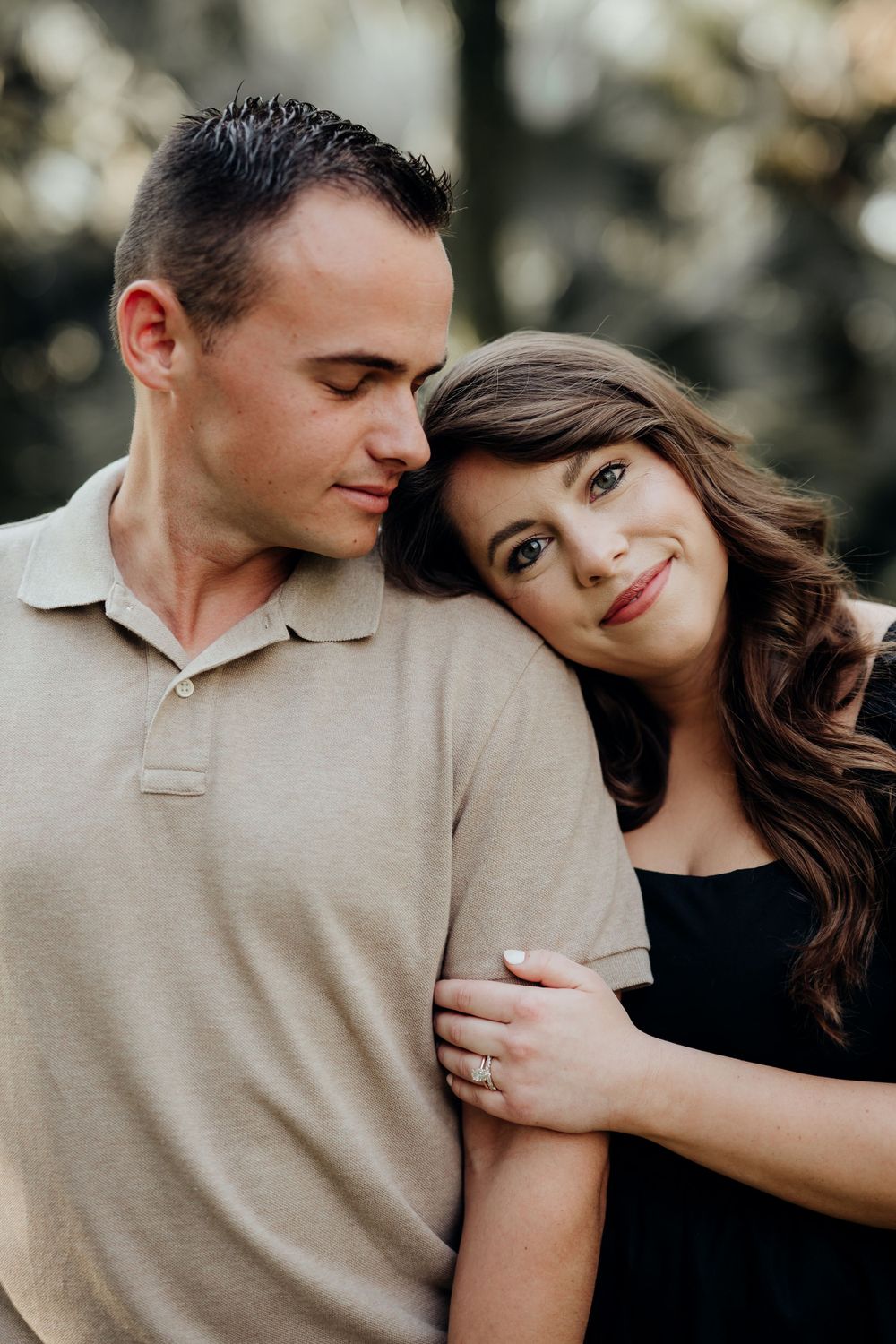 Wife resting head on husband during a couple photoshoot with green background