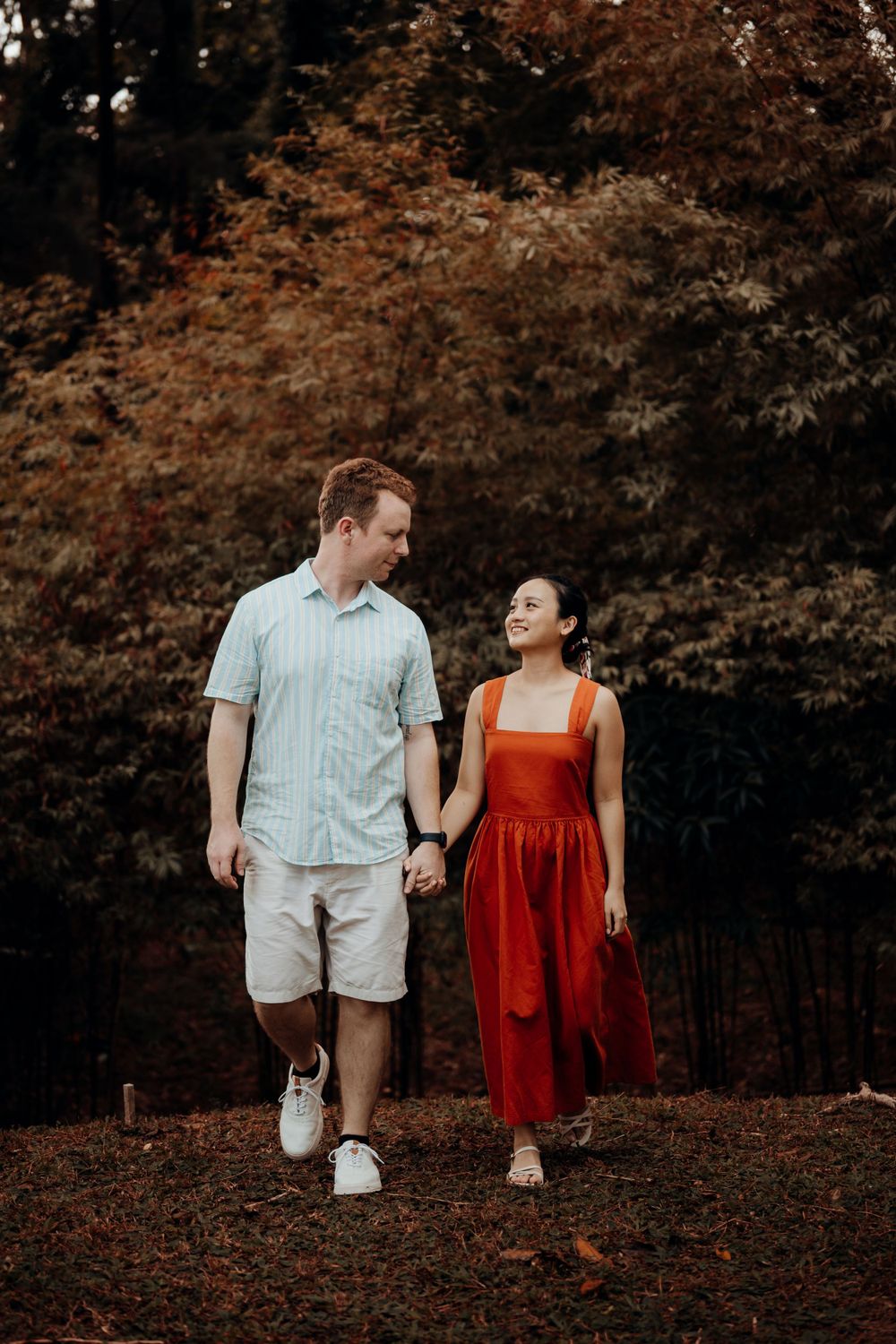 couple walking together with orange leaves background
