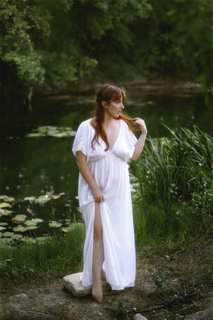 Photographie de Chaemi Studio, photographe à Montpellier. Portrait d'une femme vêtue d'une longue robe blanche au bord de la rivière