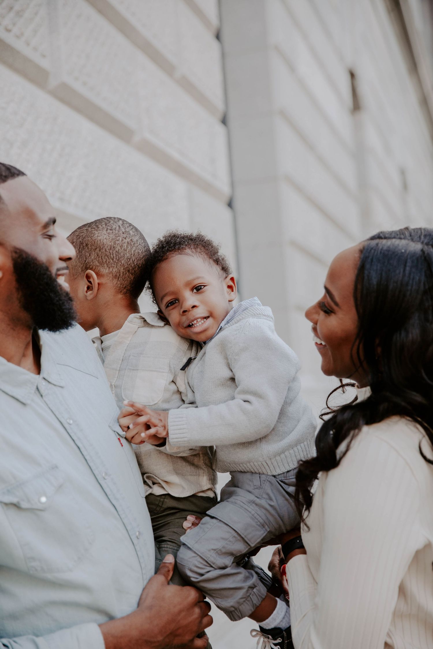 Smiling family with toddlers shares a laugh together for their family photos, taken by Anna Holman.