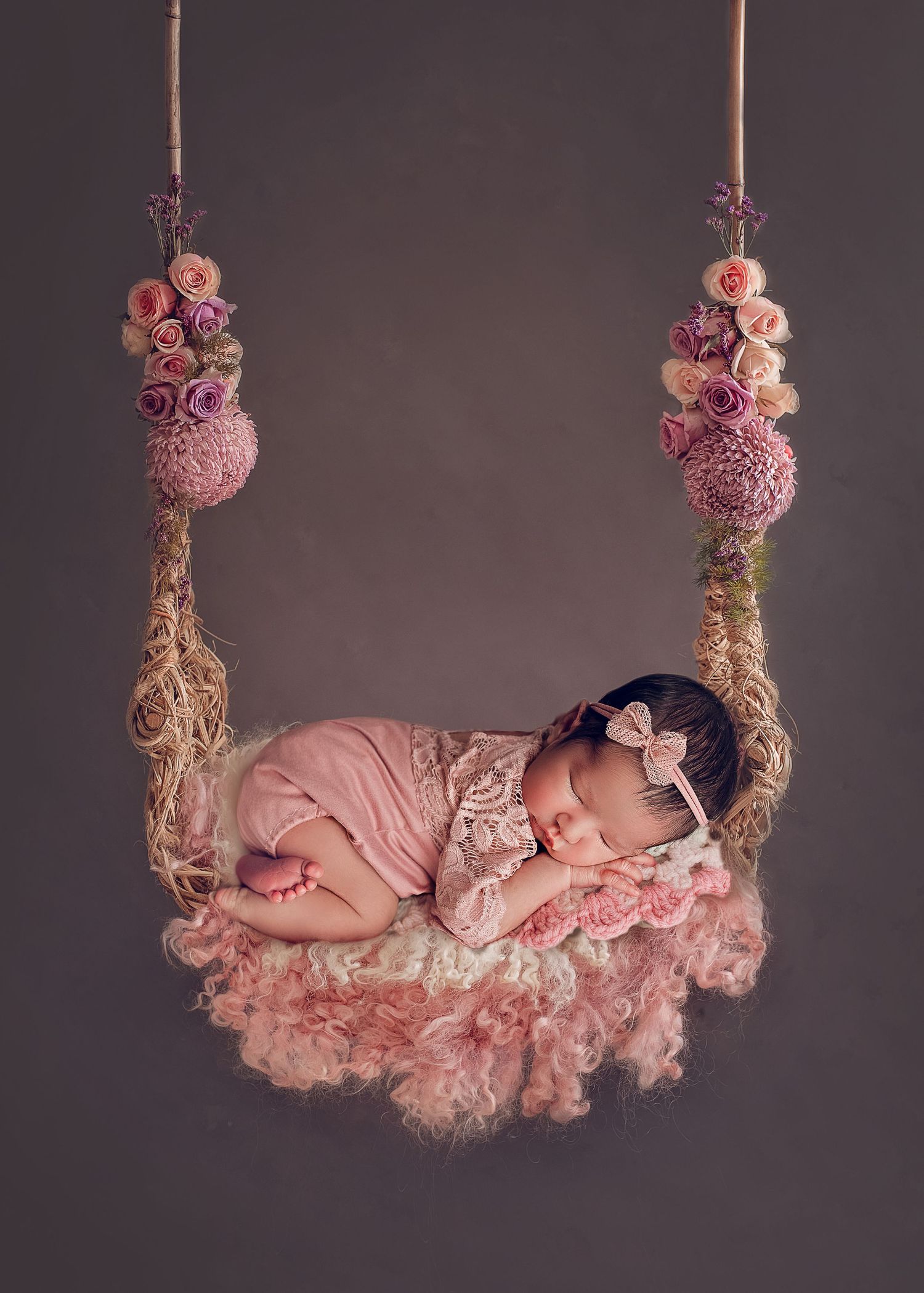 newborn baby girl on swing with flowers composite image