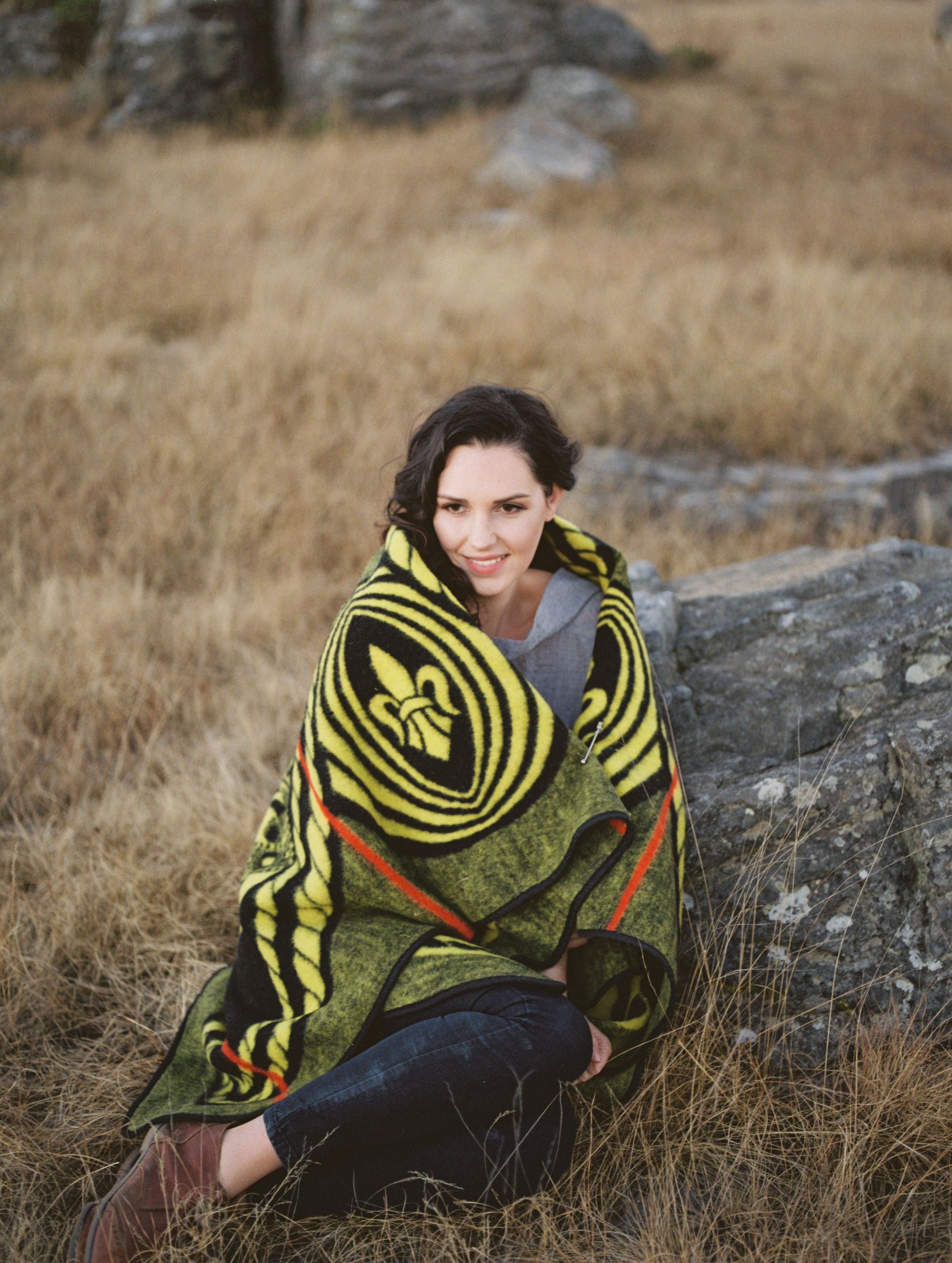 Wrapped in a traditional Basotho blanket a woman giggles into the cold.