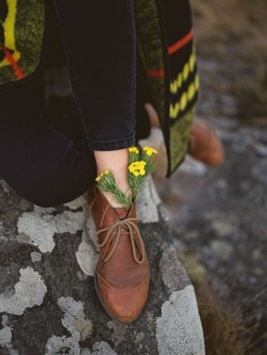 Leather shoes with wild flowers tucked into them.