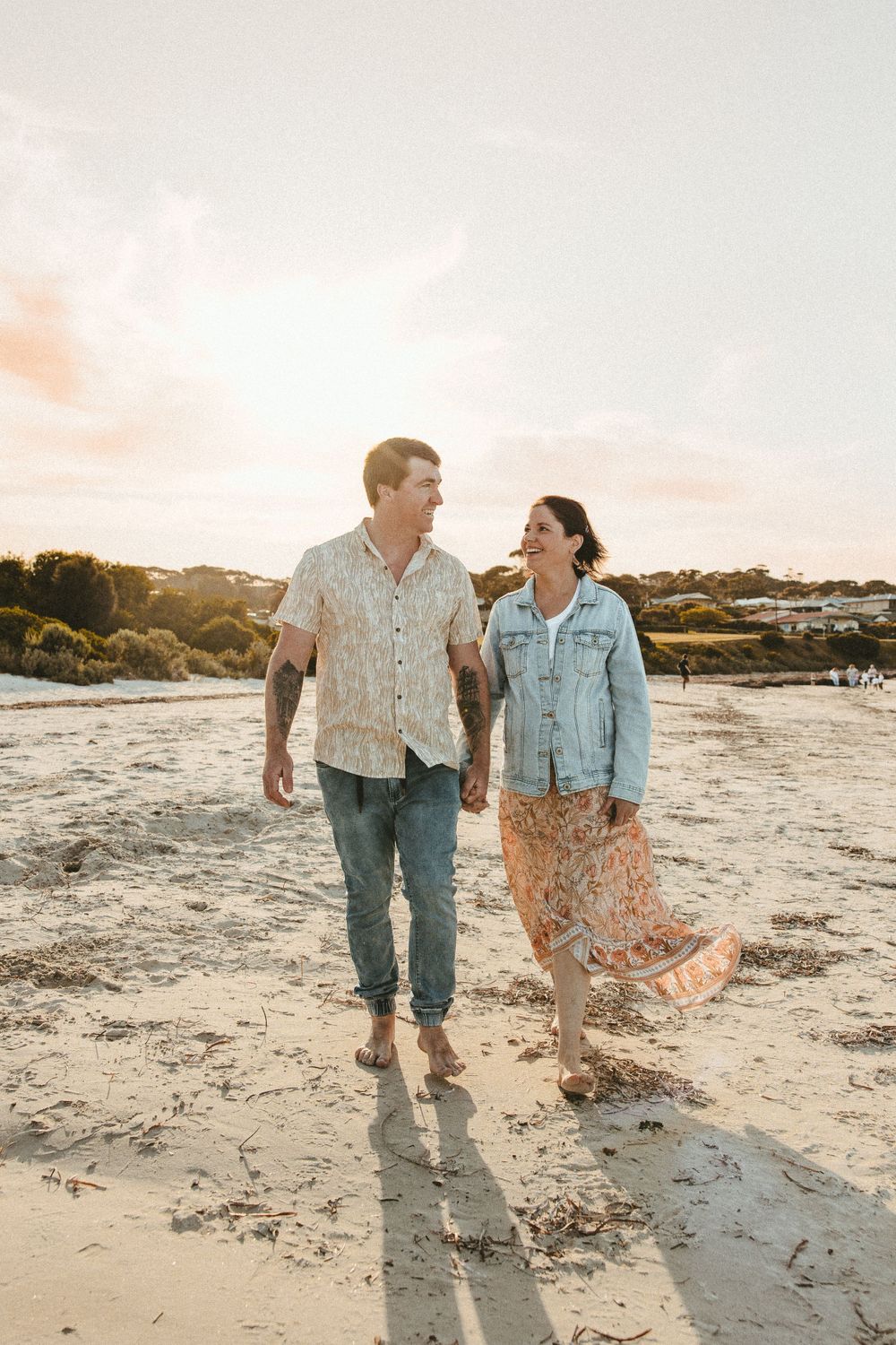 Couple taking a romantic stroll along the beach during sunset.