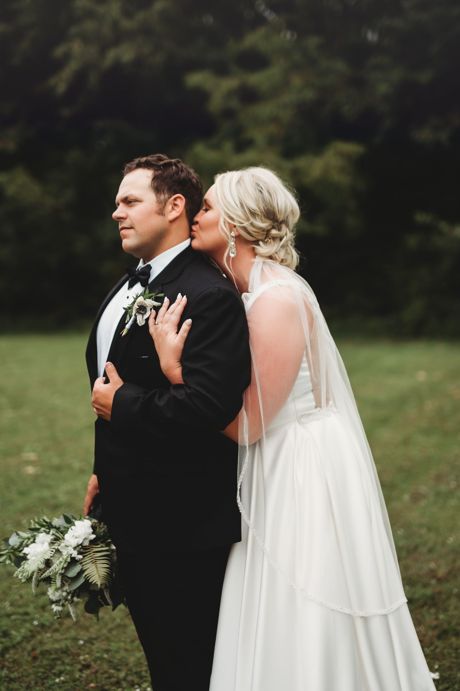 Bride and groom share an intimate first look moment in outdoor setting.