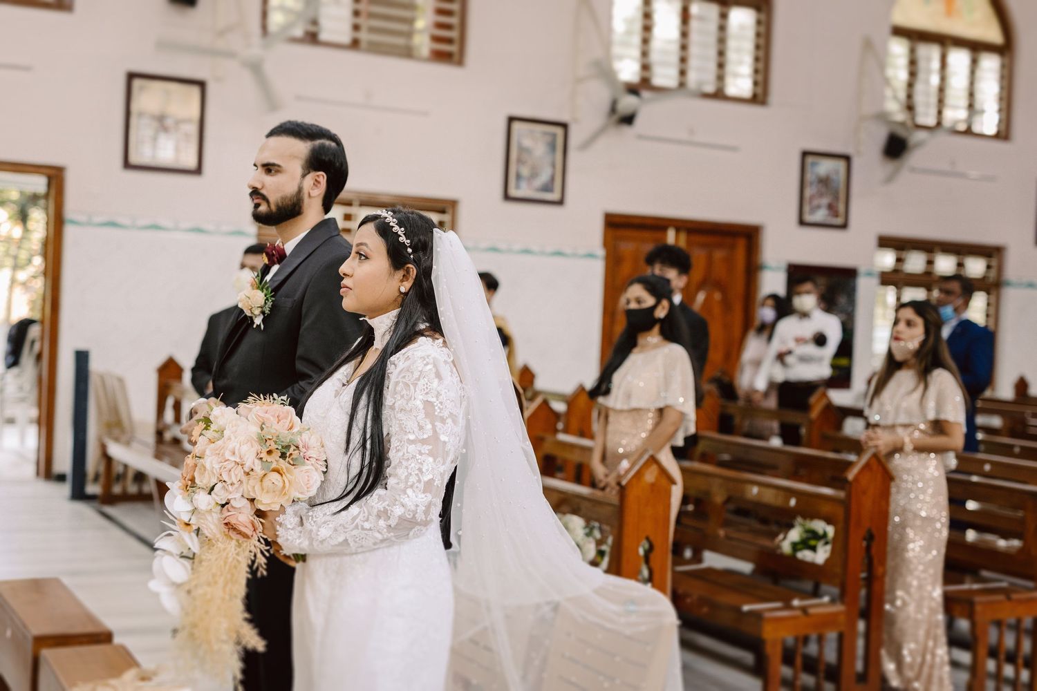 A wedding ceremony in a traditional church with pews and natural lighting.