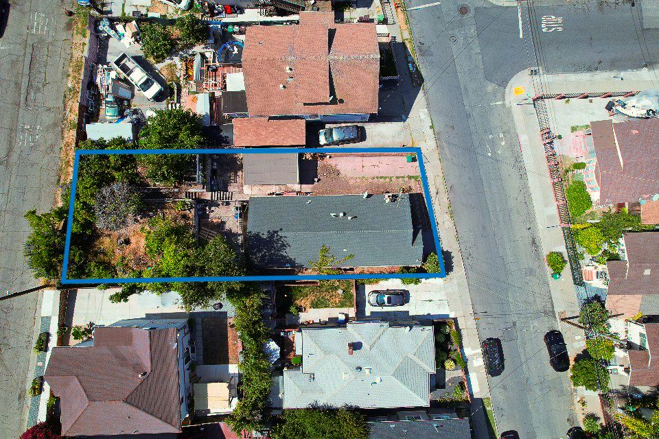 Aerial view of residential neighborhood streets and houses with varied rooflines.
