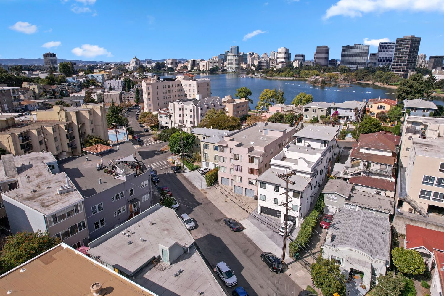 Aerial panorama of an urban skyline with modern buildings and waterfront views on a sunny day.