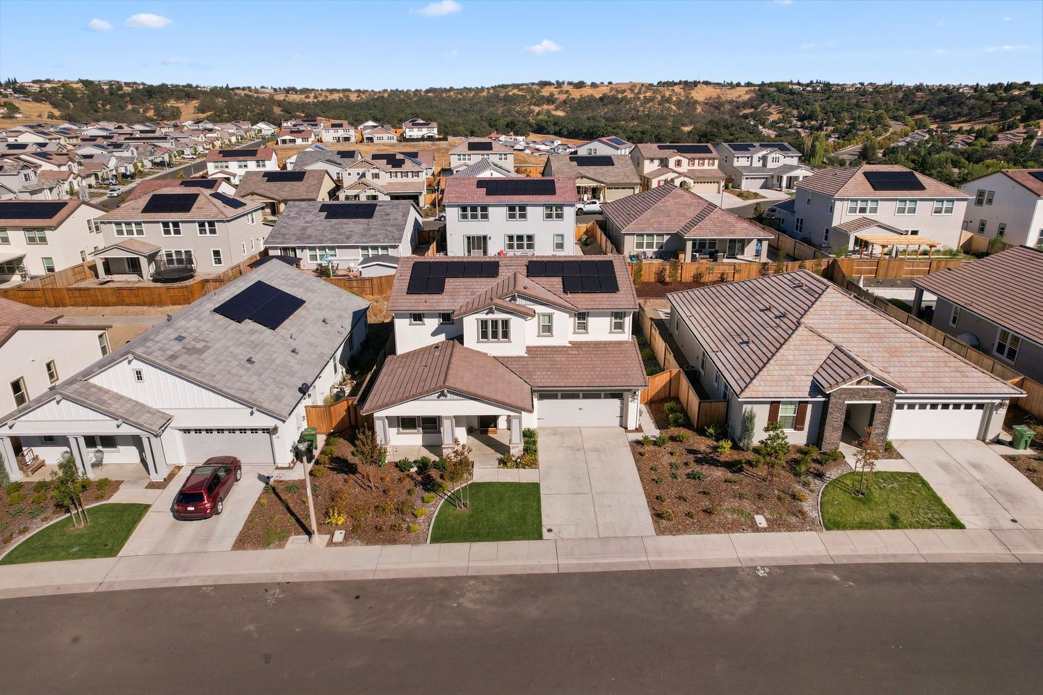 Aerial view of suburban development showing multiple single-family homes with landscaped yards.