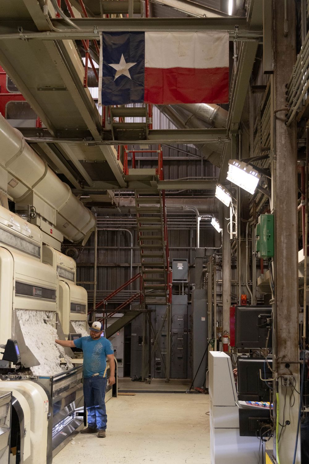 Interior view of a cotton processing facility with industrial machinery and equipment.