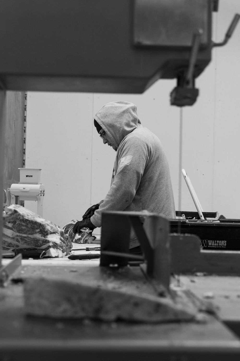 Person working at a food preparation station in black and white photography.