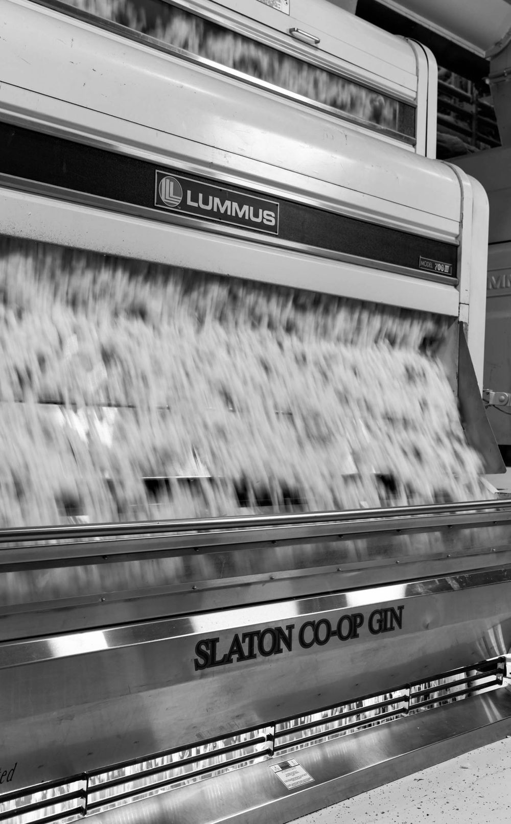 Motion blurred newspaper sheets moving rapidly through an industrial printing press conveyor system.