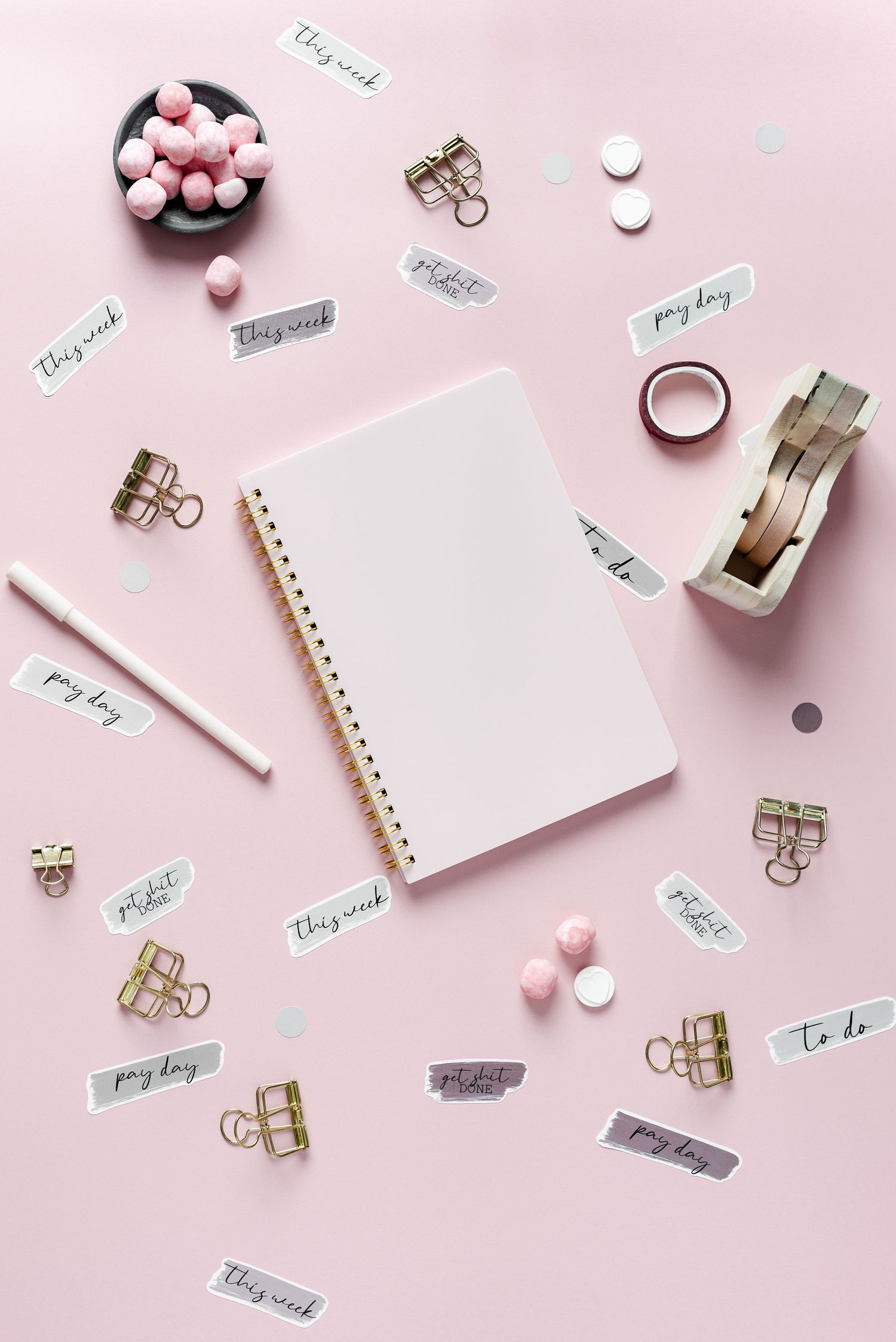 pink journal on pink backdrop with office stationery, pink sweets and inspiring stickers dotted around, pretty, feminine