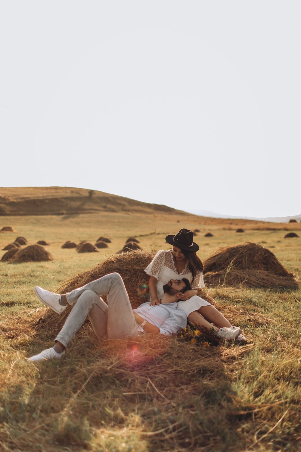 Rustic outdoor photography capturing tender moment between couple in field setting.